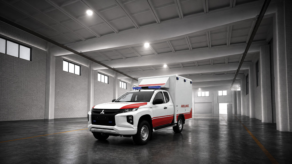 A white and red Mitsubishi Fuso truck is parked in a large, empty warehouse.