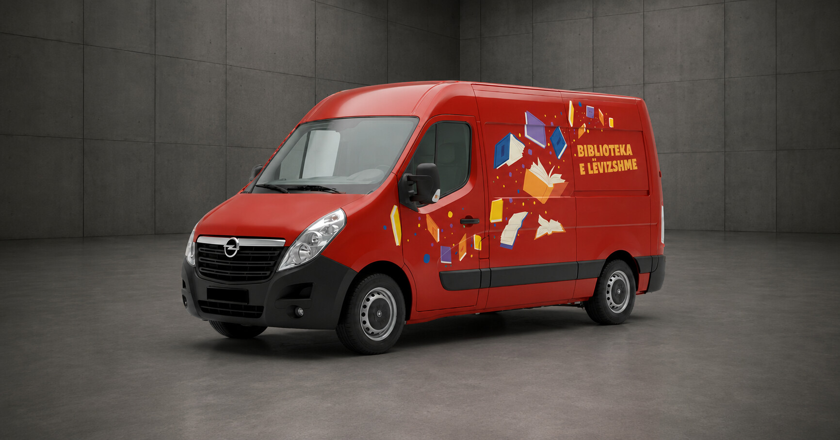A red van parked in a grey room, with the words "Biblioteca e Livrarias" written on the side, suggesting that it is a bookmobile or mobile library.