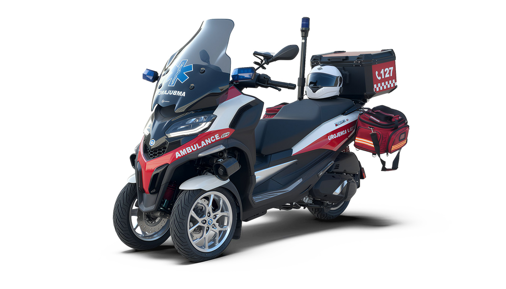 An ambulance vehicle, likely a motorcycle or scooter, with a predominantly black, red, and white color scheme, set against a dark background.