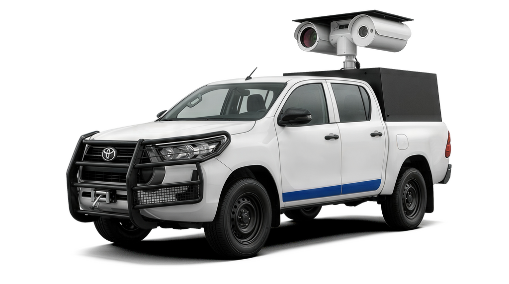A white Toyota Hilux pickup truck with a security camera mounted on top, set against a dark background.
